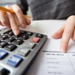 Closeup of Accountant Hands Counting on Calculator