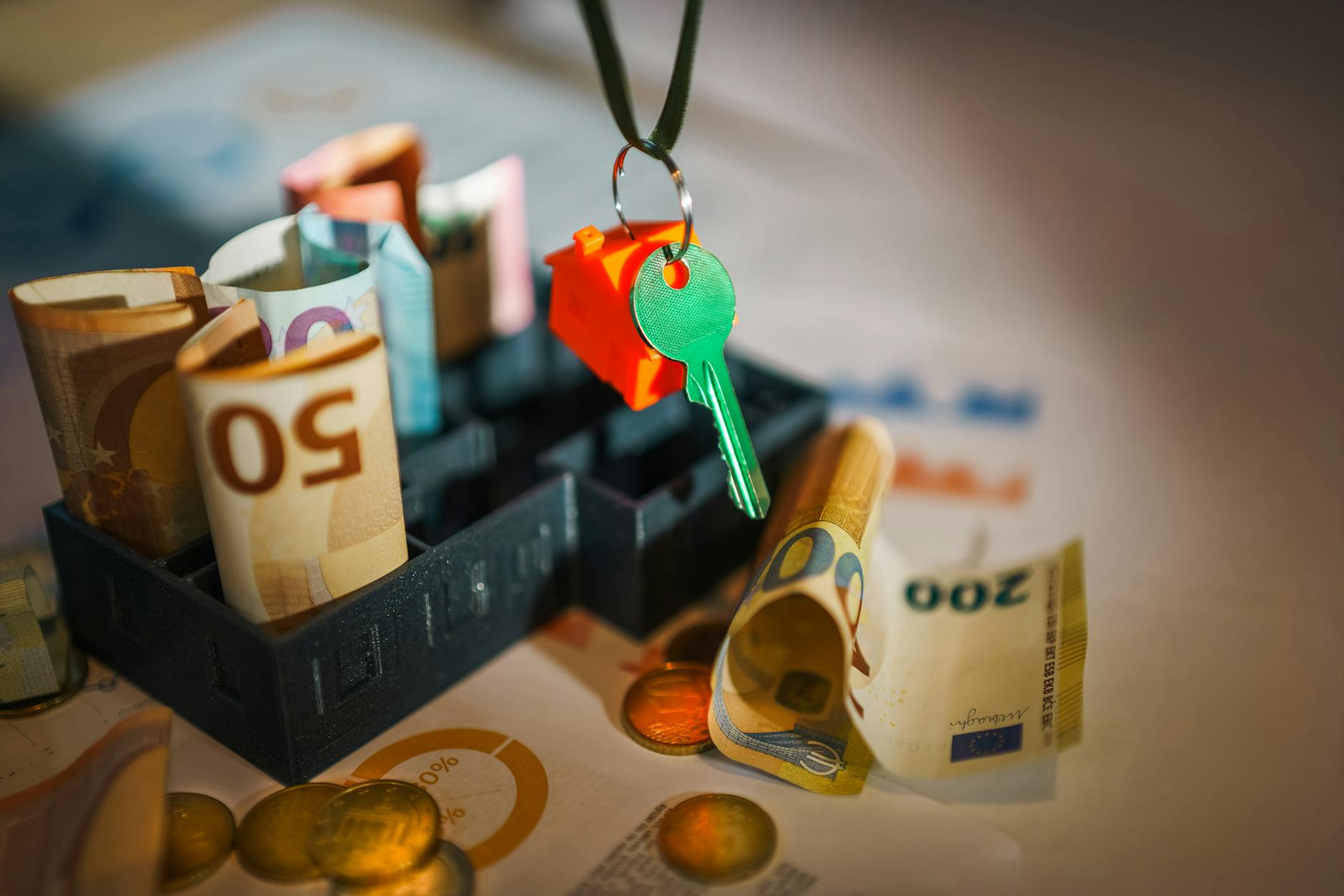 Klucz do domu położony na banknotach euro, symbol kosztów najmu