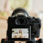 Kobieta nagrywa vlog produktowy w kuchni w domowym studio fotograficznym