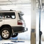 Biały SUV Land Rover na podnośniku w warsztacie podczas przeglądu
