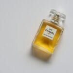 Flakon eleganckich perfum z bursztynowym płynem na białym tle