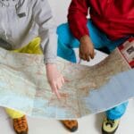 Para podróżników planuje trasę na papierowej mapie zimą
