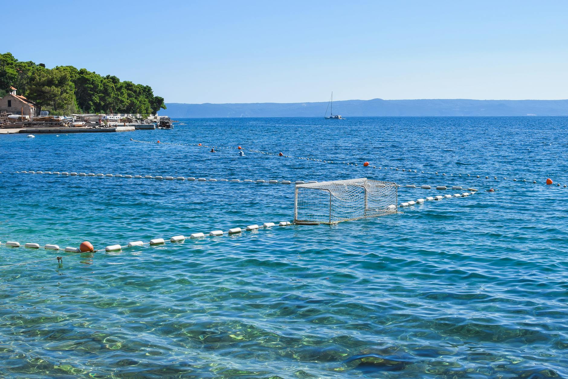 Spokojna plaża w Dalmacji z turkusowym morzem i górzystym wybrzeżem