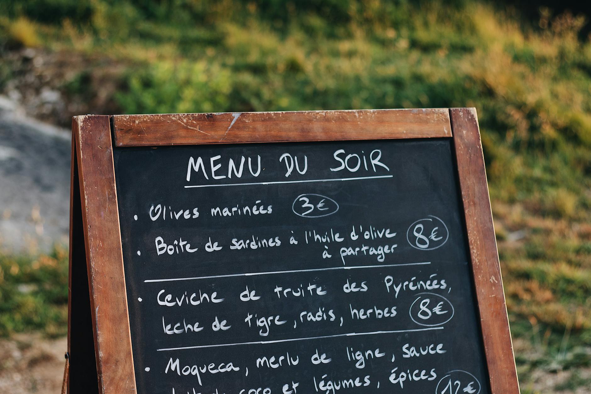 Tablica z menu przy wejściu do restauracji na świeżym powietrzu